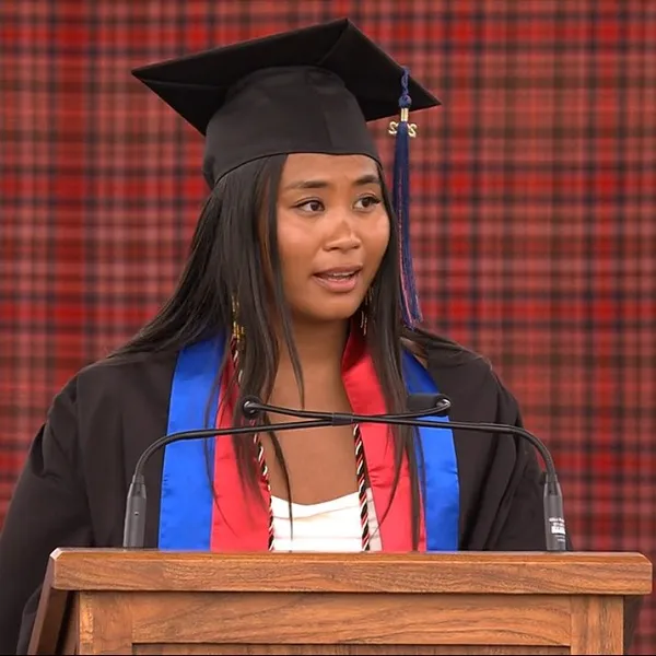 Mac Grad Pia reading peace prayer at podium