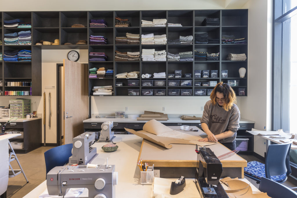 Photo of a Macalester student working in the costume shop