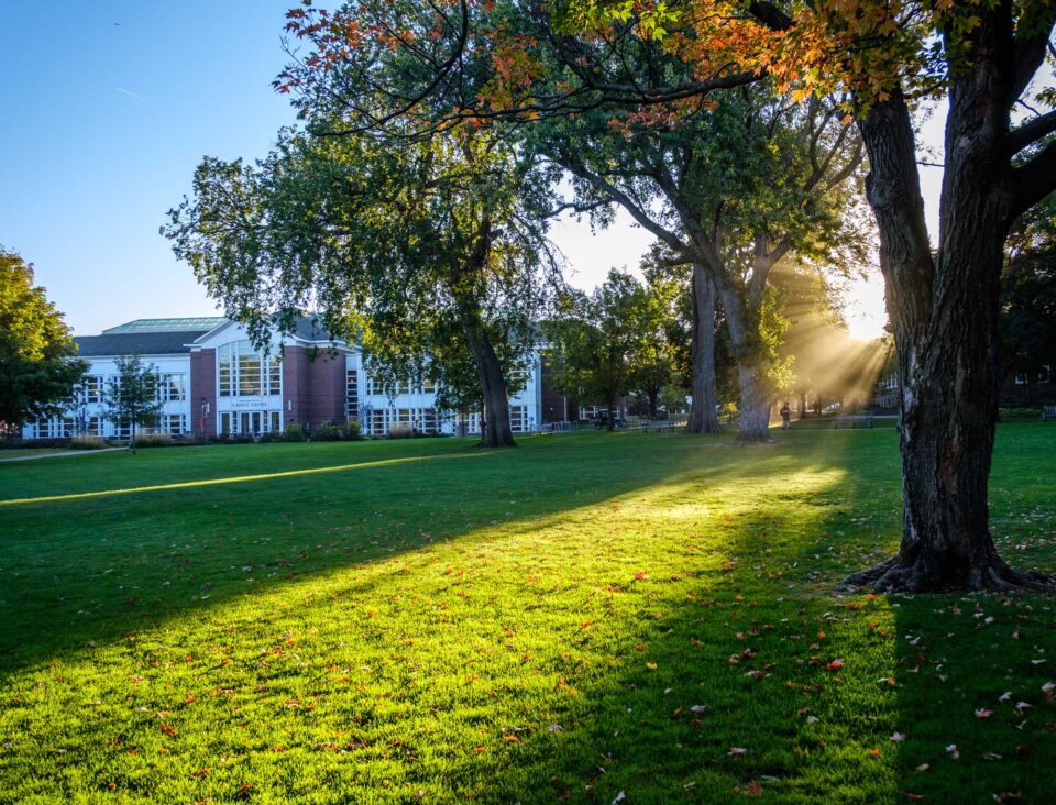 The sun shines over Macalester's Great Lawn and Campus Center