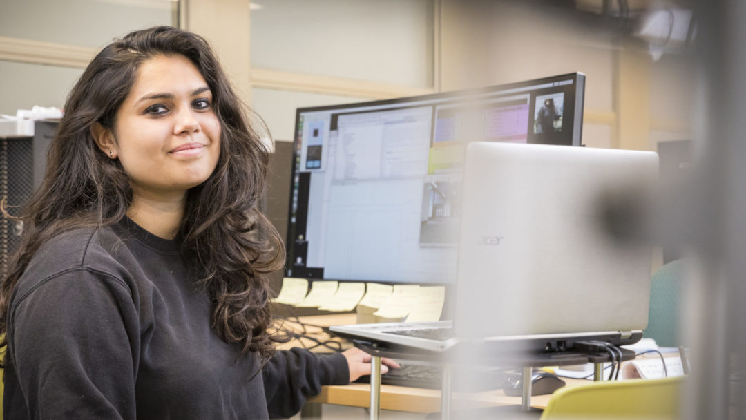 Photo of Malini Sharma working at a computer