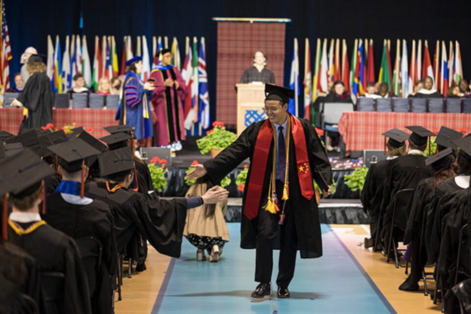 A 2023 graduate returning to their seat after walking across the stage.