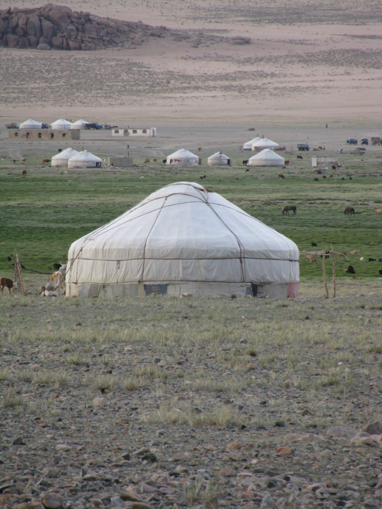 An image of a white tent-like house on a farm