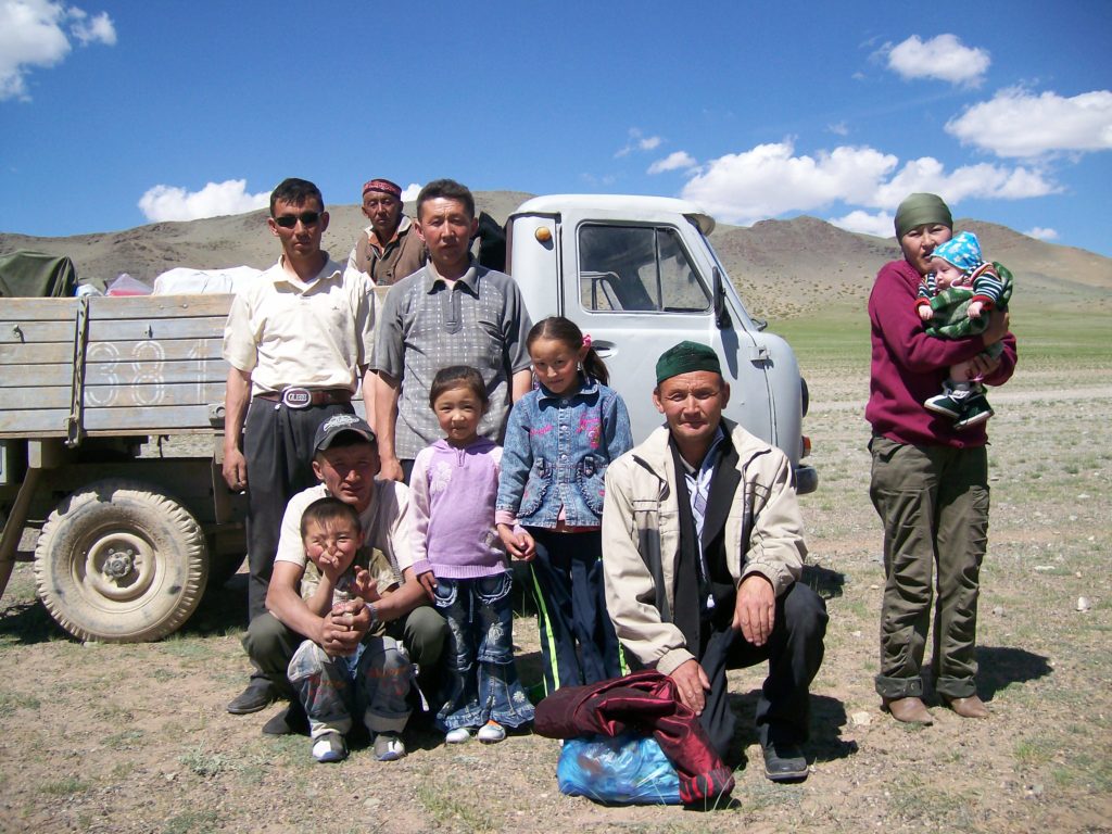A family photo of Mongolian Kazakhs standing in front of a truck