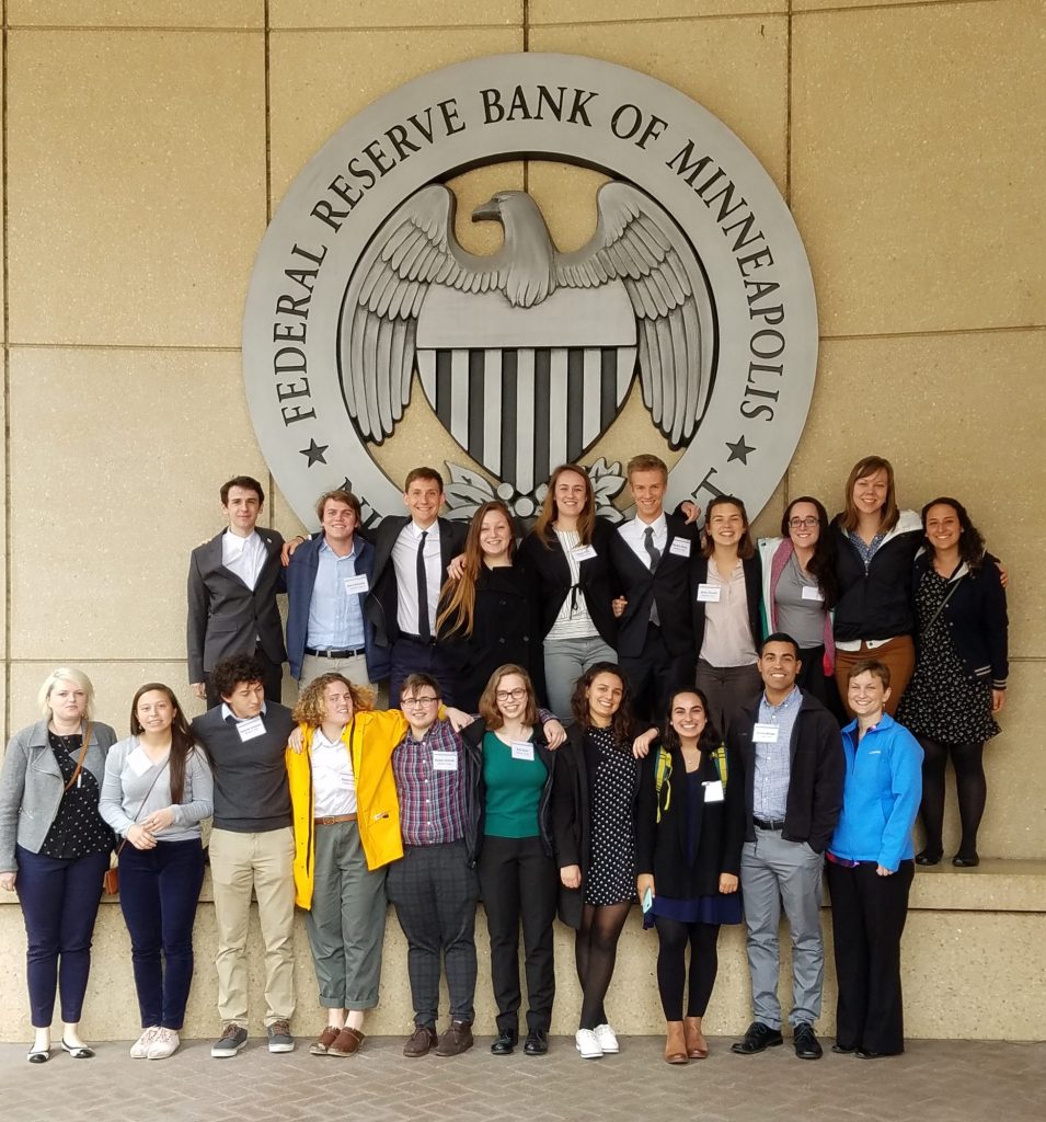 Geography students photographed in front of the Federal Reserve Bank of Minneapolis sign.