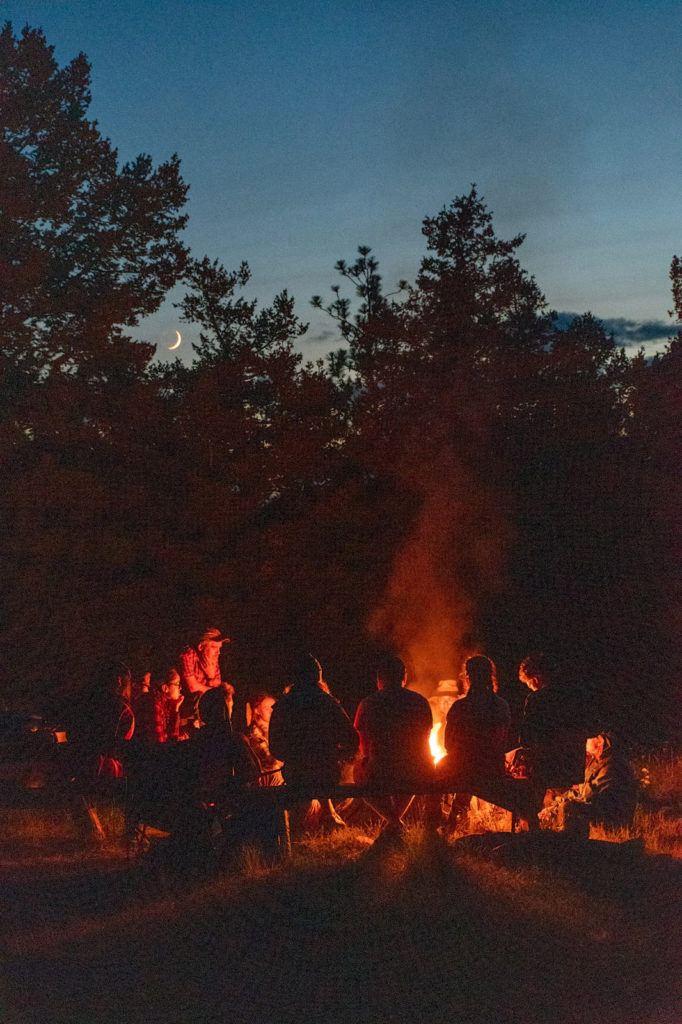 Geology students around a campfire during a field research trip.