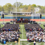 An aerial view of students, staff, and family members watching the Commencement ceremony