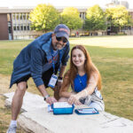 A Macalester parent and current student look at the camera and smile