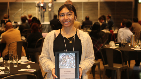 Anahi Sanchez Lazcano ’26 holds her COPAL Power and Action Award, recognized for her advocacy in immigration, housing, and education