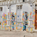 Street art of a girl sitting on a pile of books and reading