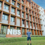 A students stands outside Nanyang Business School