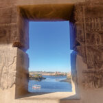 A view of the Nile River in Cairo through a stone window with ancient hieroglyphs