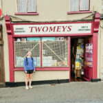 A student stands in front of a store called TWOMEYS in Ireland