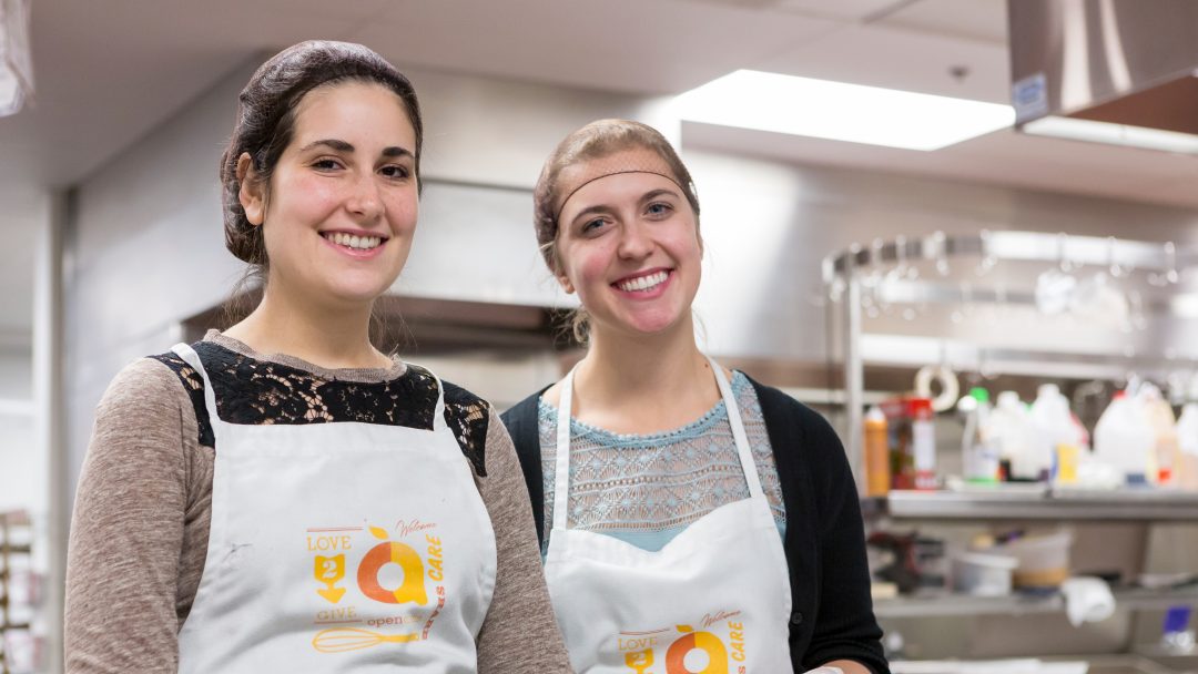 Photo of two students volunteering at a food shelter