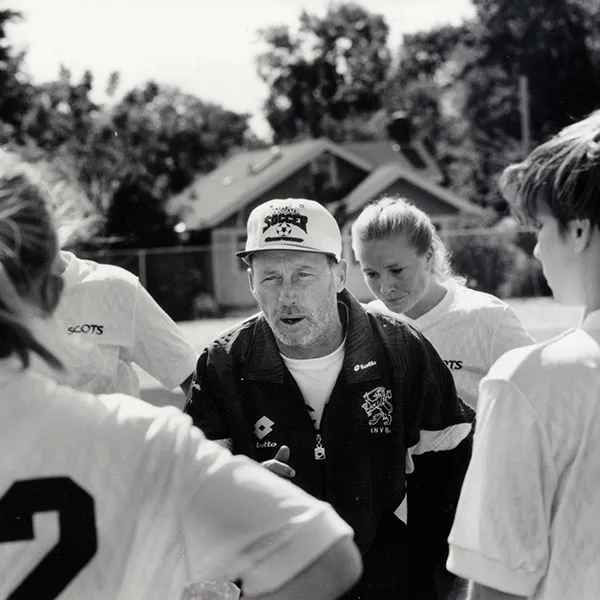 Coach Leaney talking within a Women's Soccer Team huddle