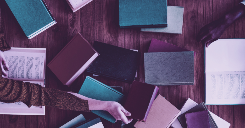 image of book piles and hands reaching for books