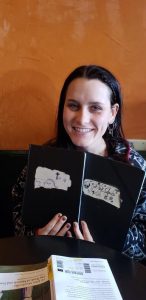 Koada Heacock holding her English major's journal in which she composed her second capstone project, Rat Fuck Footprints