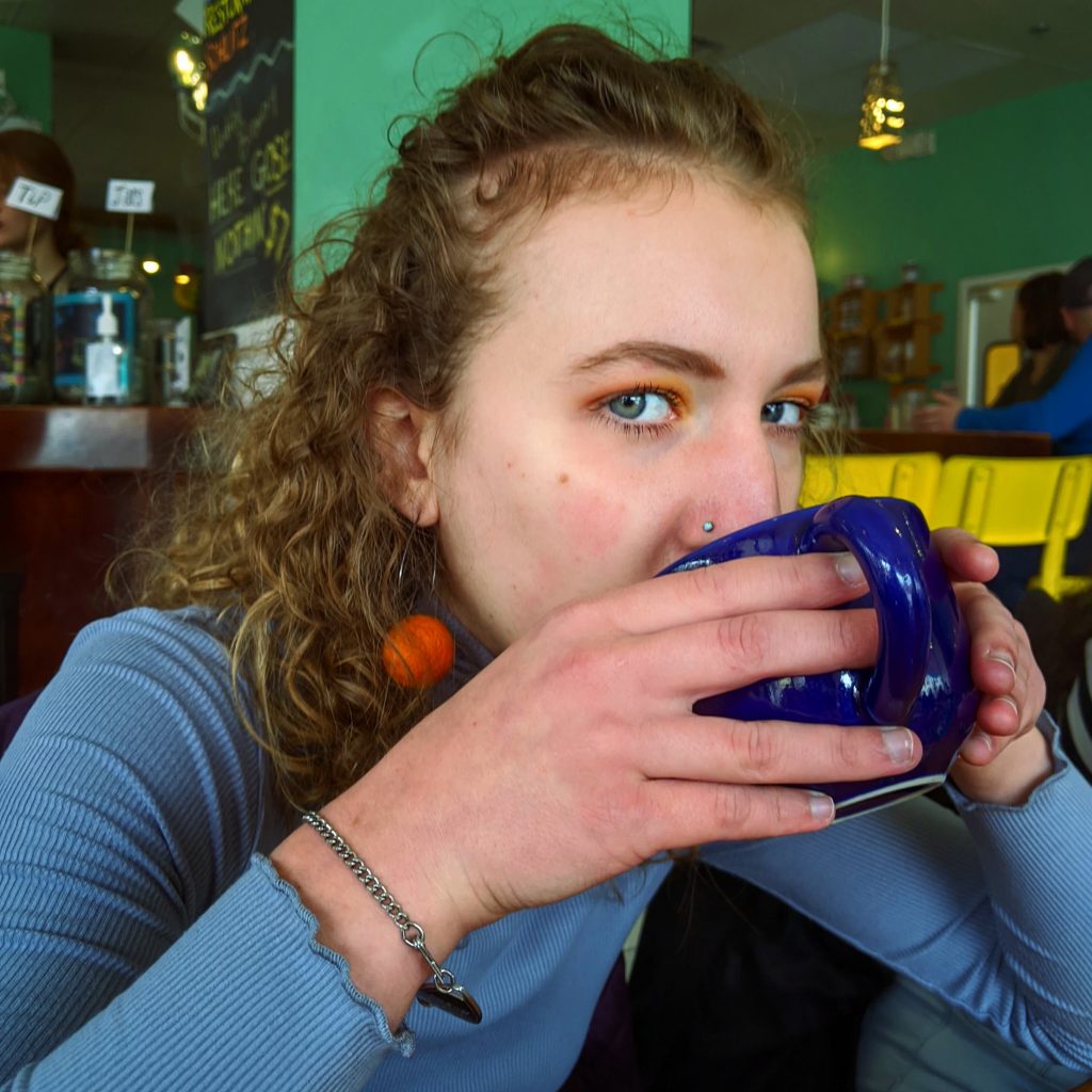 Photo of Schukar '22 drinking coffee.