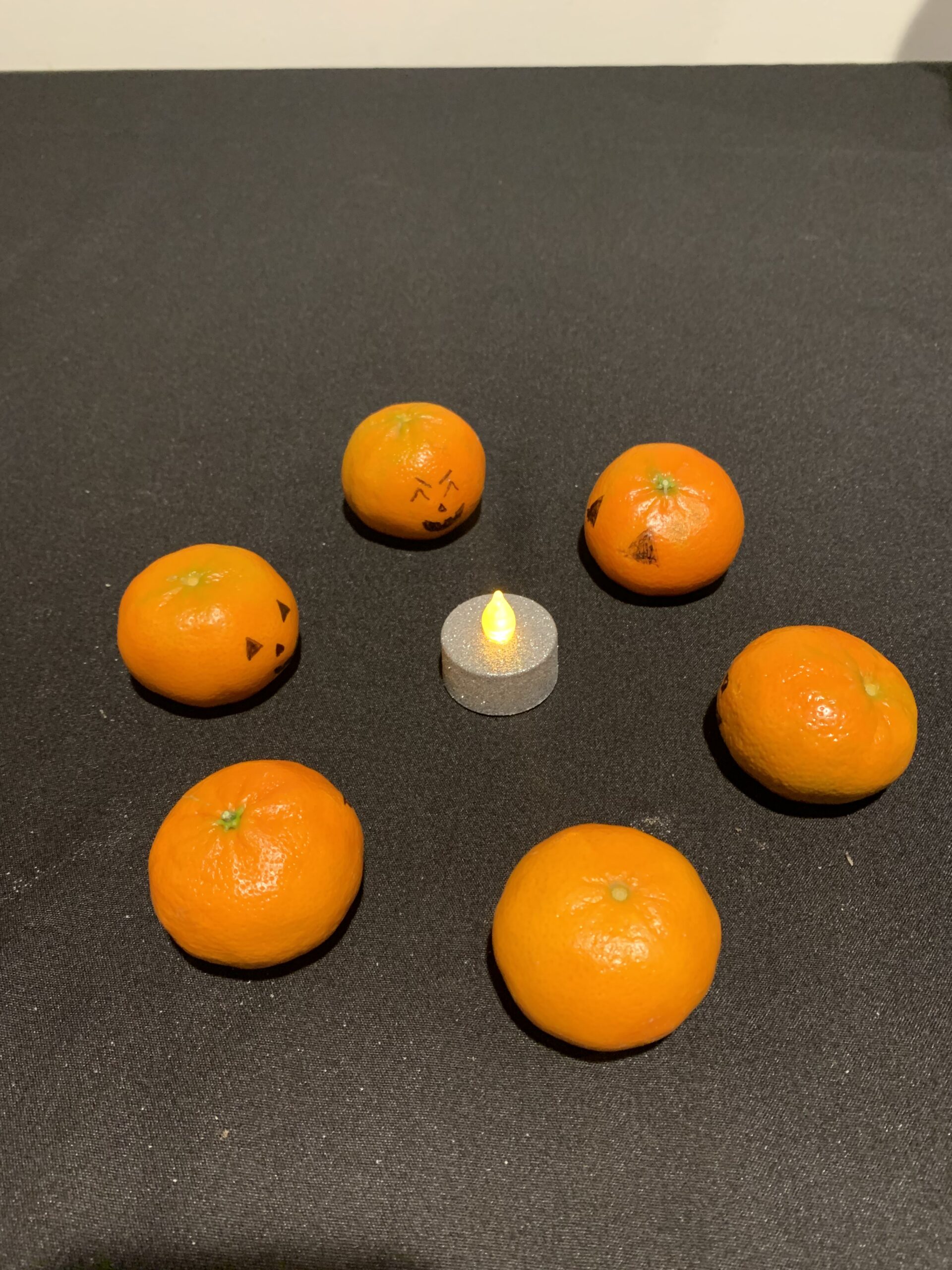 Jack-o-lantern clementines gather for a seance