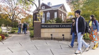 Mac students walking past the Macalester College sign