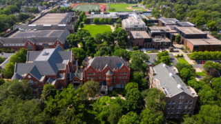 A drone shot over Macalester College. Several academic buildings as well as the Library and athletic fields are visible.